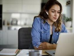 woman business owner watching virtual conferenc on her laptop